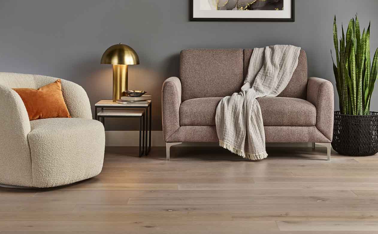 Hardwood flooring in a living room with a neutral loveseat and accent chair